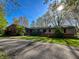 Charming single story home with brick and siding, circular driveway, and mature trees on a sunny lot at 4305 Lincoln Rd, Indianapolis, IN 46228