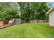 Large backyard with lush green lawn, mature trees, and a chicken coop with enclosed run at 4904 Kessler Blvd N Dr, Indianapolis, IN 46228