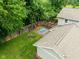 This aerial view showcases a cozy backyard with a patio, fire pit, and beautifully landscaped garden beds at 4904 Kessler Blvd N Dr, Indianapolis, IN 46228