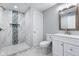 Stylish bathroom featuring marble tile, a walk-in shower with blue accents, and a white vanity at 4904 Kessler Blvd N Dr, Indianapolis, IN 46228