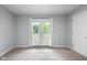 Bedroom with light grey walls, carpet, and a door leading to the outside deck at 4904 Kessler Blvd N Dr, Indianapolis, IN 46228
