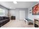 Versatile bonus room with neutral walls, light wood flooring, and a plaid sofa at 4904 Kessler Blvd N Dr, Indianapolis, IN 46228