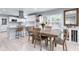 Well-lit dining area with a large wooden table, chairs, and a modern kitchen in the background at 4904 Kessler Blvd N Dr, Indianapolis, IN 46228