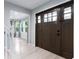 Bright entryway with hardwood floors, featuring a solid front door and views into the living spaces at 4904 Kessler Blvd N Dr, Indianapolis, IN 46228