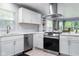 Bright kitchen showcasing stainless appliances, white cabinets and a connection to the dining room at 4904 Kessler Blvd N Dr, Indianapolis, IN 46228