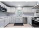 Bright kitchen with white cabinets, stainless steel appliances, and a window over the sink at 4904 Kessler Blvd N Dr, Indianapolis, IN 46228