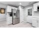 Kitchen with stainless steel appliances, white cabinetry, and adjacent entryway at 4904 Kessler Blvd N Dr, Indianapolis, IN 46228