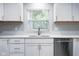 Kitchen featuring white cabinets, stainless steel dishwasher, and ample countertop space at 4904 Kessler Blvd N Dr, Indianapolis, IN 46228
