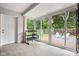 Bright sunroom features white brick walls, tile flooring, sliding doors to the backyard, and exercise equipment at 4904 Kessler Blvd N Dr, Indianapolis, IN 46228