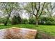 Wood deck in a green backyard, surrounded by mature trees and lush grass at 5141 Annette St, Indianapolis, IN 46208