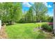 Private backyard features a well-maintained lawn, mature trees, a storage shed, and colorful landscaping at 5341 Armstrong Dr, Indianapolis, IN 46237