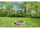 View of fire pit surrounded by trees in the backyard on a sunny day at 5341 Armstrong Dr, Indianapolis, IN 46237