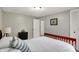 Cozy bedroom with neutral walls, white bedding, a black nightstand, and an opening to another room at 5341 Armstrong Dr, Indianapolis, IN 46237