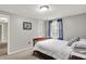 Bright bedroom features neutral walls, plush carpet, and natural light from the window with blue curtains at 5341 Armstrong Dr, Indianapolis, IN 46237