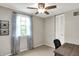 Comfortable bedroom features a ceiling fan, window with curtains, a desk, and closet with paneled doors at 5341 Armstrong Dr, Indianapolis, IN 46237
