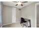 Simple bedroom features a desk, ceiling fan, paneled closet doors, and neutral carpet and walls at 5341 Armstrong Dr, Indianapolis, IN 46237