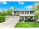 Charming two-story home features a well-manicured lawn and an attached two-car garage at 5341 Armstrong Dr, Indianapolis, IN 46237