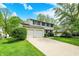 Traditional home boasts a two-car garage, green lawn, and mature trees at 5341 Armstrong Dr, Indianapolis, IN 46237