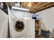 A laundry room featuring a washer and dryer with storage shelving and exposed ceiling at 5341 Armstrong Dr, Indianapolis, IN 46237