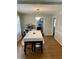 Well-lit dining room with a large table, hardwood floors, and a view into the kitchen at 5841 E Julian Ave, Indianapolis, IN 46219