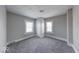 Bright bedroom with two windows and neutral paint, enhanced by modern gray carpeting at 623 Arbor Ave, Indianapolis, IN 46221