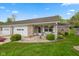 Charming brick home featuring a one-car garage and a cozy front porch with a white bench at 6640 S New Jersey St, Indianapolis, IN 46227