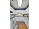 Bright kitchen featuring white cabinets, wood-look flooring, and modern appliances at 6640 S New Jersey St, Indianapolis, IN 46227