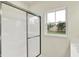 Bathroom shower boasts glass doors and a bright window at 7136 Jackson Dr, Cumberland, IN 46229