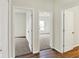 Hallway with visible bedroom views and neutral carpeting, illuminated by natural light at 7136 Jackson Dr, Cumberland, IN 46229