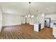 Bright open-concept living room and kitchen with hardwood floors and modern light fixtures at 7136 Jackson Dr, Cumberland, IN 46229