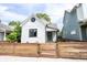 A charming white home with a green door and freshly stained wooden fence at 722 E Minnesota St, Indianapolis, IN 46203