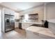Bright kitchen featuring white cabinets, stainless steel appliances, floating shelves, and marble countertops at 722 E Minnesota St, Indianapolis, IN 46203