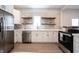 Well-lit kitchen with stainless steel appliances, white cabinets, floating shelves, and marble countertops at 722 E Minnesota St, Indianapolis, IN 46203