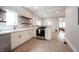 Open kitchen with white cabinets, stainless steel range, floating shelves, and marble countertops at 722 E Minnesota St, Indianapolis, IN 46203