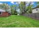 Exterior view of a backyard with a grassy lawn, shed, and fenced perimeter at 7804 Wawasee Dr, Indianapolis, IN 46250