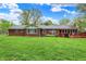 View of home's brick back exterior, lush lawn, and patio deck at 7804 Wawasee Dr, Indianapolis, IN 46250