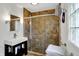Bathroom featuring tiled shower with glass doors, modern vanity, and window for natural light at 7804 Wawasee Dr, Indianapolis, IN 46250