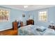Charming bedroom featuring hardwood floors, two windows, and a vanity with a blue chair at 7804 Wawasee Dr, Indianapolis, IN 46250