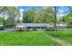 Beautiful home featuring a brick facade, lush lawn, and mature trees in a serene setting at 7804 Wawasee Dr, Indianapolis, IN 46250