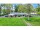 Landscaped front yard with mature trees, well-kept lawn, and a brick home at 7804 Wawasee Dr, Indianapolis, IN 46250