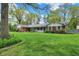 Beautifully landscaped front yard highlights this one-story home, showcasing its curb appeal with mature trees at 7804 Wawasee Dr, Indianapolis, IN 46250