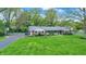 Well maintained single story home with green grass and a charming white fence at 7804 Wawasee Dr, Indianapolis, IN 46250