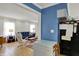 Open-concept living room with tile flooring, blue accent walls, and view into the adjacent seating area at 7804 Wawasee Dr, Indianapolis, IN 46250