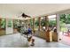 Enclosed sunroom with tile flooring, a ceiling fan, and expansive windows offering views of the outdoor space at 7804 Wawasee Dr, Indianapolis, IN 46250