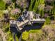 Aerial view of estate showcasing meticulously landscaped grounds, circular driveway, and expansive roofs at 8103 N Pennsylvania St, Indianapolis, IN 46240