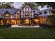 Backyard with patio and dining area; exterior of Tudor-style home with manicured lawn at 8103 N Pennsylvania St, Indianapolis, IN 46240