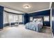 A stylish bedroom with bright blue accent wall, large windows, and a work desk at 8103 N Pennsylvania St, Indianapolis, IN 46240
