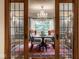 A lovely formal dining room with elegant chandelier, large window, and seating for eight at 8103 N Pennsylvania St, Indianapolis, IN 46240