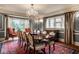 A gorgeous dining room featuring a chandelier, large wood table, and bay window with beautiful curtains at 8103 N Pennsylvania St, Indianapolis, IN 46240