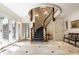 Elegant foyer with a curved staircase, marble floors, and custom millwork at 8103 N Pennsylvania St, Indianapolis, IN 46240